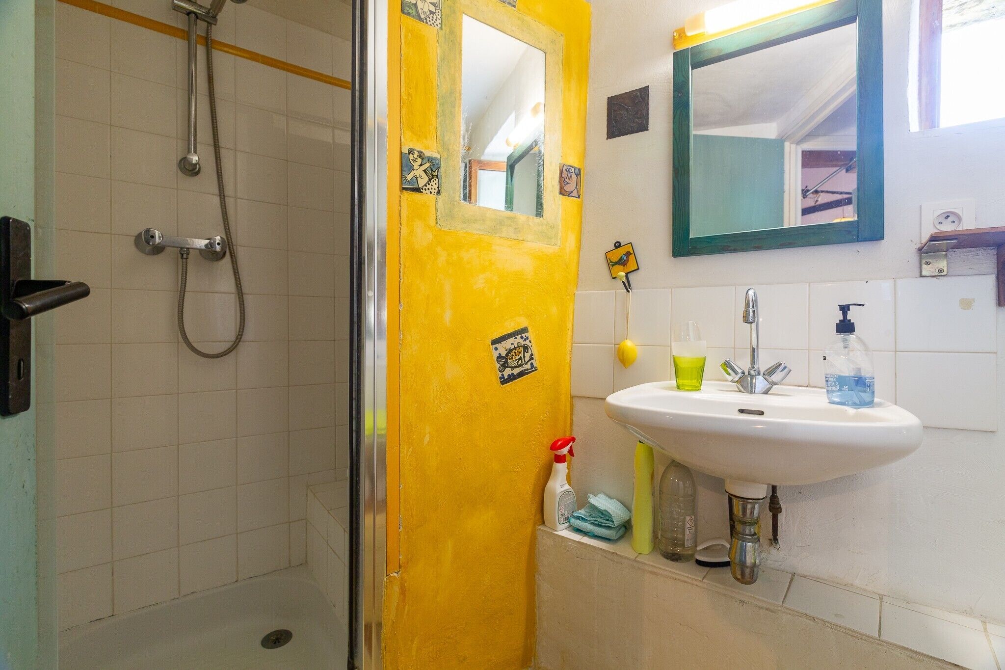 A bathroom with a shower, sink, and mirror.