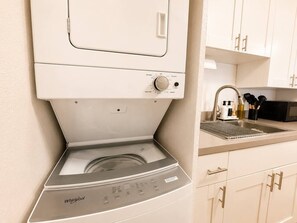 Eine Whirlpool Spülmaschine in einer Küche mit Spüle, Schränken und einer Mikrowelle.