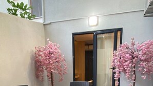 A dining area with a table and chairs, a potted plant, and a sliding door. - Santra Bosphorus Pansiyon (Istanbul)