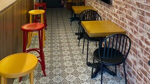 A bar area with a brick wall, a TV, and a painting. - Santra Bosphorus Pansiyon (Istanbul)