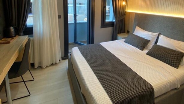 A hotel room with a bed, a desk, and a view through a door. - Santra Bosphorus Pansiyon (Istanbul)