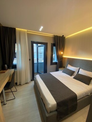 A hotel room with a bed, a desk, and a view through a door. - Santra Bosphorus Pansiyon (Istanbul)