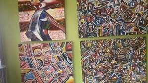 Un muro decorato con quattro quadri astratti e colorati.