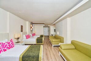 A hotel room with a bed, two bedside tables, a sofa, a chair, and a small table. - Orange County Alanya Family Concept (ANTALYA)