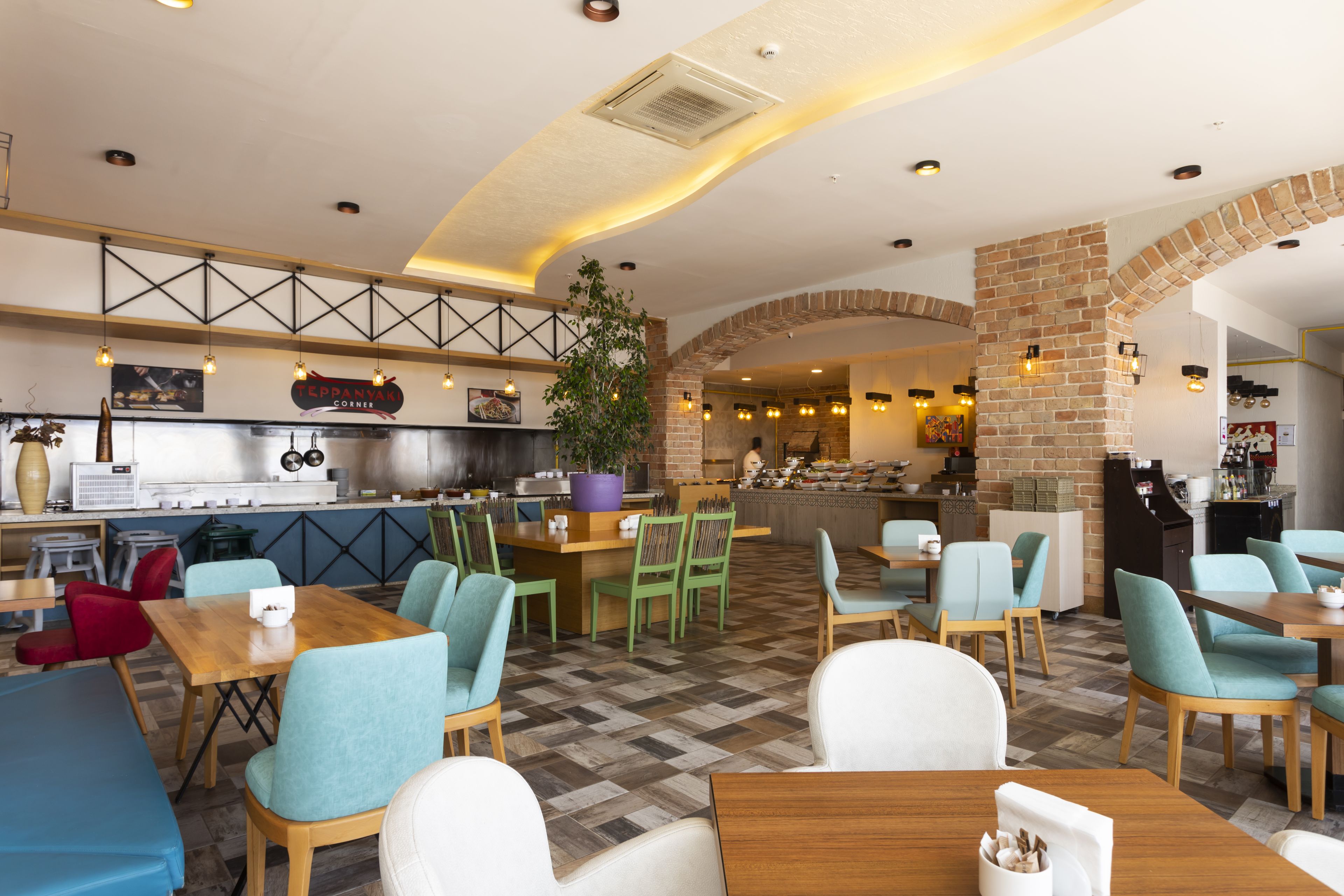 Ein Restaurant mit Barbereich, Sitzgelegenheiten und einer Küche im Hintergrund.