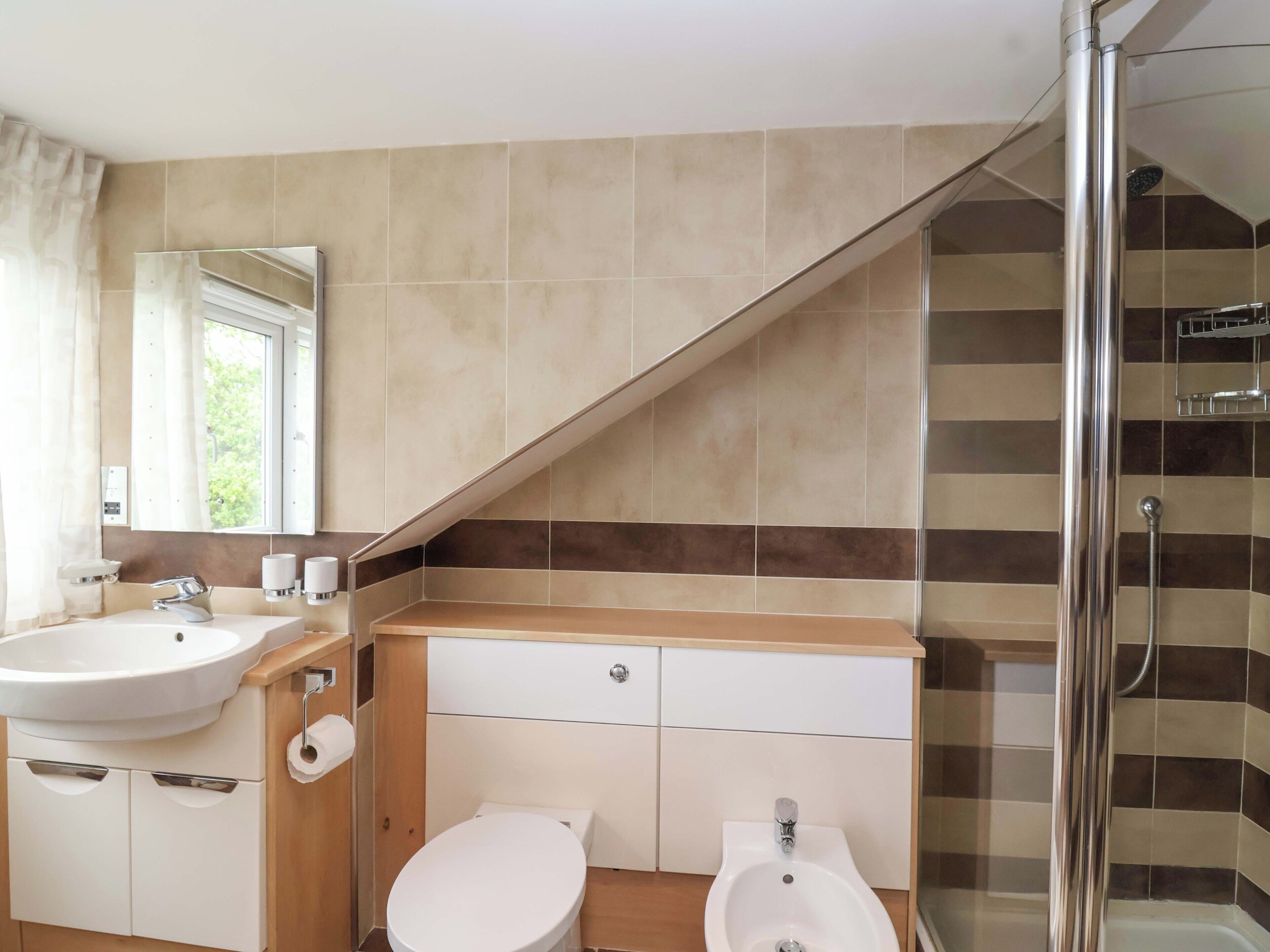 A bathroom with a sink, toilet, and shower.