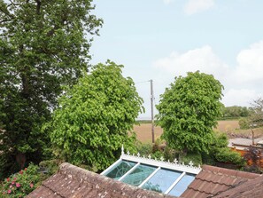 A residential area with a large tree, a power line, and a house with a sloped roof. - Meadowcroft (Watchet)