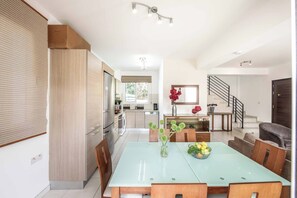 Eine moderne Küche mit Essbereich, einer Treppe und einem Wohnzimmer.