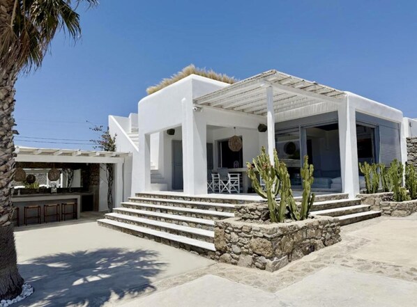 A modern white building with a covered patio, stone steps, and cacti. - Casa Gekko Mykonos - Villa w Private Pool & Sea View (Mykonos)