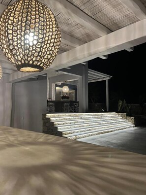 A modern outdoor area with a stone staircase leading to a covered seating area. - Casa Gekko Mykonos - Villa w Private Pool & Sea View (Mykonos)