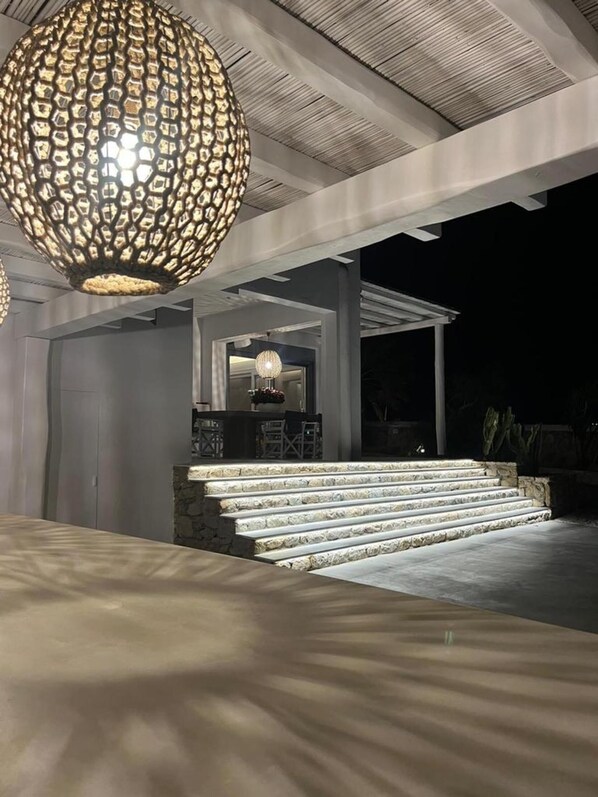 A modern outdoor area with a stone staircase leading to a covered seating area. - Casa Gekko Mykonos - Villa w Private Pool & Sea View (Mykonos)