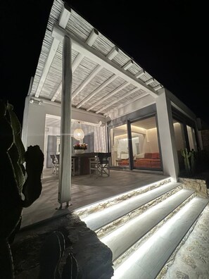 Een modern huis met een terras, een eethoek en een woonkamer.