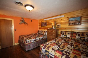 Quarto com duas camas, parede de madeira, pássaro empoleirado e placa de Dakota do Sul.