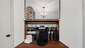 A coffee station with a Keurig coffee maker, a sign, and a decorative wall piece. - Game Room+Xbox, 15 Min to Memphis & Tunica Casino (Horn Lake)