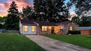 A two-story house with a front porch, a driveway, and a well-maintained lawn. - Game Room+Xbox, 15 Min to Memphis & Tunica Casino (Horn Lake)