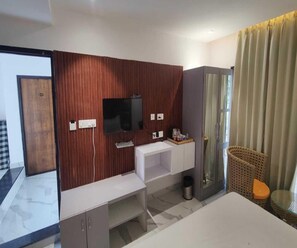A modern bathroom with a wooden panel wall, a mirror, a sink, a toilet, and a shower area. - Clubhouse Swarnagarh Nature Retreat Udaipur (Udaipur)