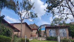 A stone house with a brick exterior, a stone staircase, and a small garden area. - 1bhk Nature View Villa With Private Balcony (Udaipur)