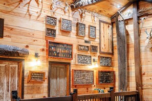 A wooden interior with framed animal skulls and antlers, wooden walls, and a bench.