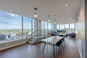 A spacious interior with large windows, a staircase, and a seating area.