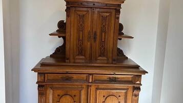 Een houten kast met decoratieve houtsnijwerken en een versierde bovenkant.