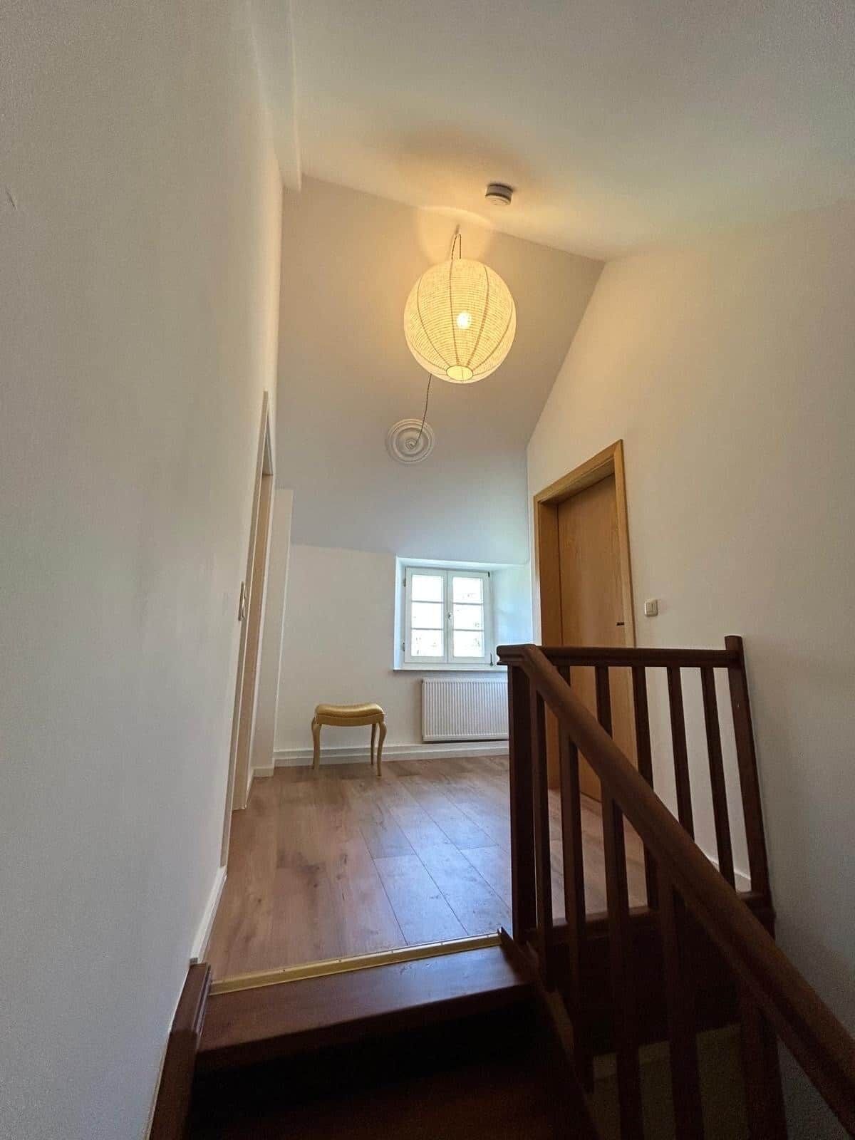 A staircase with wooden railings leading to a landing.