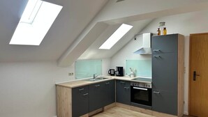 Een moderne keuken met een dakraam, een ingebouwde oven en een houten kast.