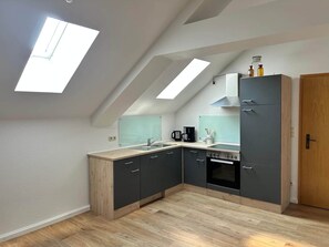 Une cuisine moderne dotée d’une lucarne, d’un four encastré et d’un meuble en bois.