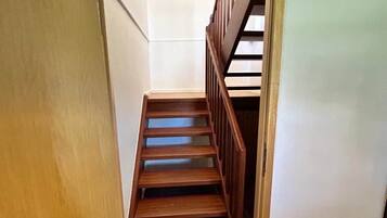 Una escalera de madera con barandilla, que conduce a una plataforma.
