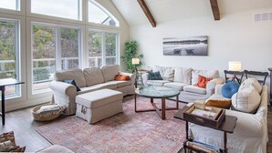 A spacious living room with large windows, a cozy fireplace, and a comfortable seating area.