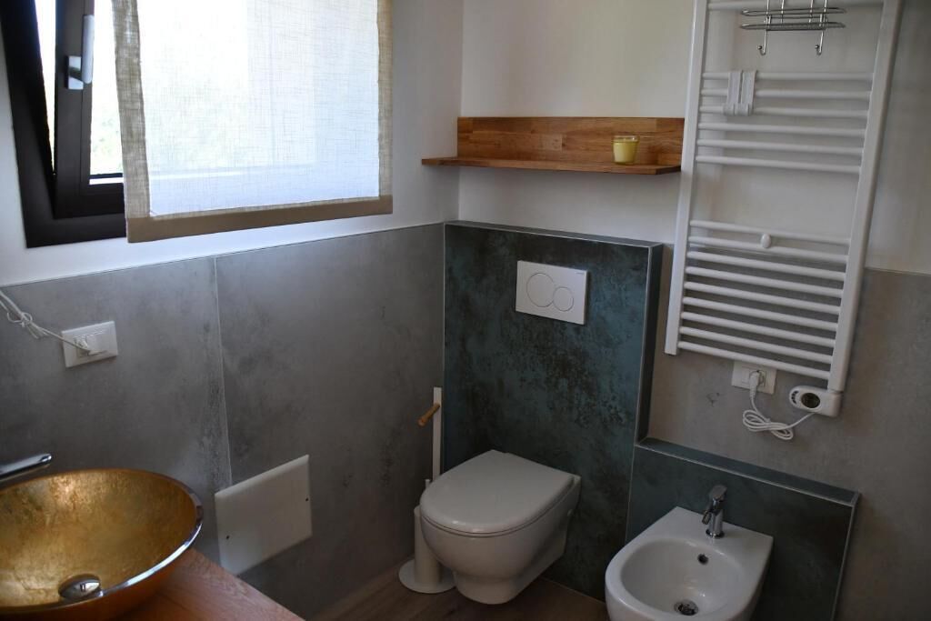 Une salle de bain équipée de toilettes, d’un lavabo et d’un porte-serviettes.
