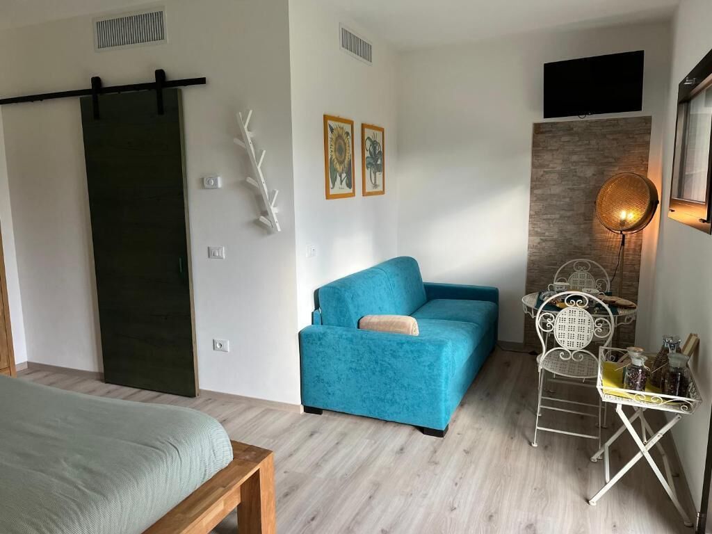 Chambre Quadruple Deluxe, plusieurs lits, fumeurs, vue parc | Coin séjour | TV connectée de 45 cm avec chaînes par câble