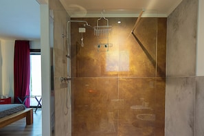 A modern shower with a glass door, a bench, and a view of the outside. - Marimastè (Roncade)