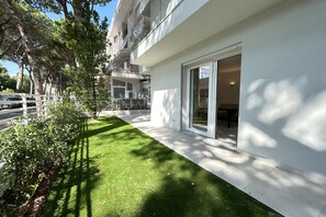 Ein modernes Gebäude mit gepflegtem Rasen, großen Fenstern und heller Fassade.