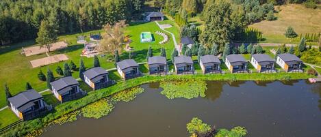 A lakeside property with multiple cabins, a playground, and a well-maintained lawn.