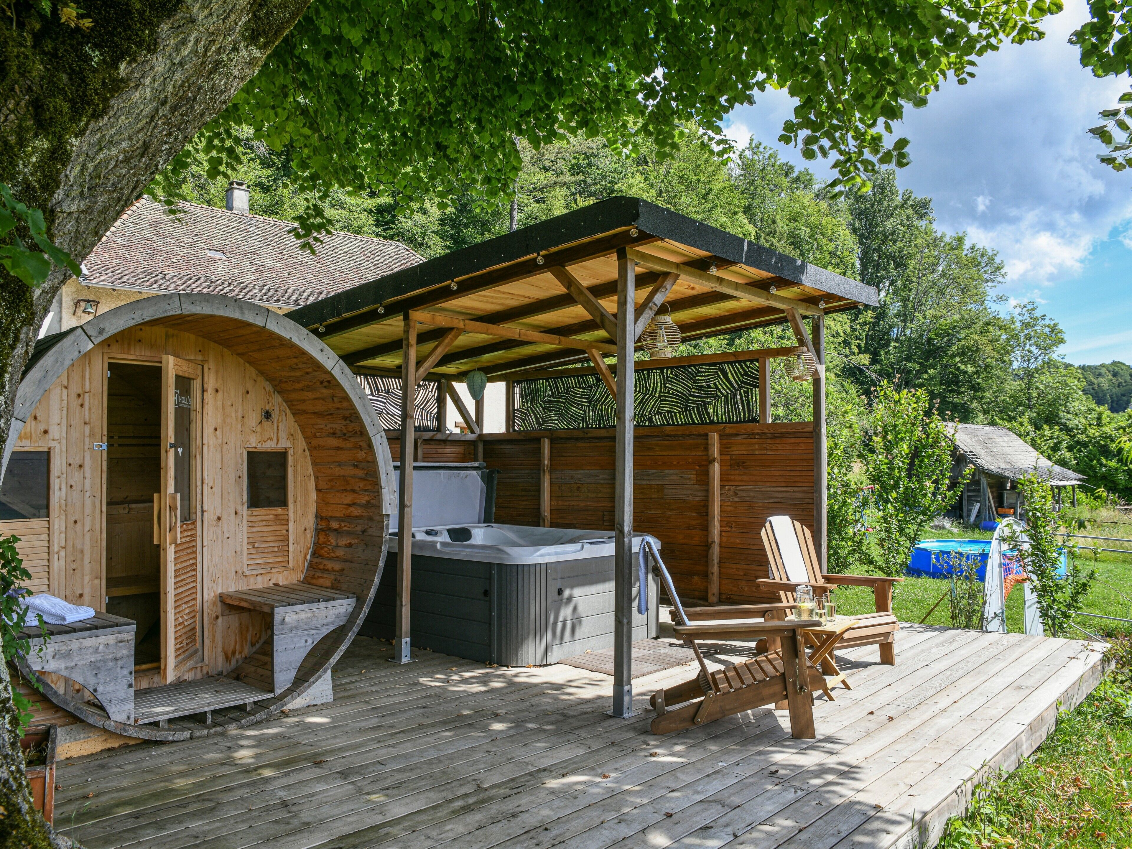 Uma cabana de madeira com banheira de hidromassagem, um alpendre coberto e um deck de madeira.