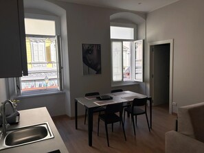Una cucina moderna con zona pranzo, ampie finestre e televisore a schermo piatto.