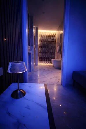 Une salle de bain moderne avec une grande baignoire, un sol en marbre et un mur ornĂ© dâun motif en chevrons.