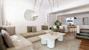 A modern living room with a sectional sofa, a white coffee table, and a large mirror. - Breathtaking house with private rooftop in Condesa (Ciudad de México)