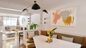 A modern living room with a dining table, sofas, and a large abstract painting. - Breathtaking house with private rooftop in Condesa (Ciudad de México)