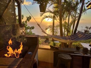 Una hamaca, un pozo de fuego y vistas del atardecer sobre el océano.