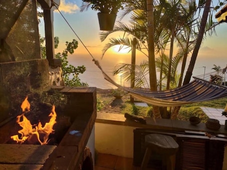 A hammock, a fire pit, and a view of the sunset over the ocean.. Apartment 'Casa' with Sea View, Wi-Fi and Air Conditioning