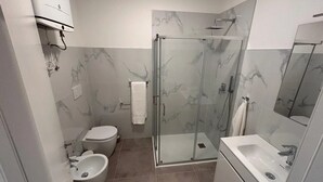 A modern bathroom with a glass shower enclosure, a toilet, a bidet, and a sink. - Apartment 'Verdi' with Wi-Fi and Air Conditioning (Gorizia)