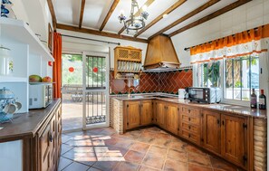 A kitchen with wooden cabinets, a microwave, and a coffee maker. - Country House 'Villa El Tejo' with Sea Views, Wi-Fi, and Air Conditioning (Frigiliana)