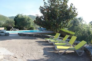 A poolside area with lounge chairs and a pool.
