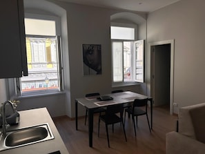 Una cucina moderna con zona pranzo, ampie finestre e televisore a schermo piatto.