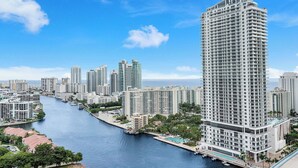 Un hotel di grandi dimensioni con piscina, situato vicino a una banchina con altri edifici.