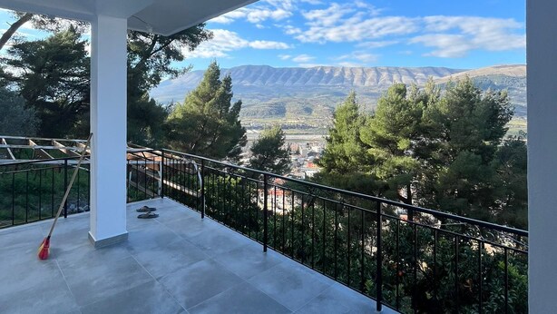 Un balcó amb vista despejada a muntanyes i arbres.