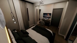 A modern bedroom with a bed, a desk, and a television. - Fethibey Otel (Bartın)
