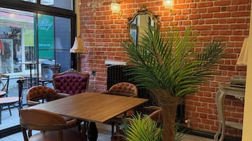 Un comedor con pared de ladrillo, una araña y un ventanal grande.