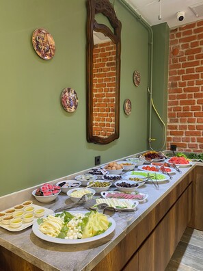 Een buffet met diverse gerechten en een spiegel aan de muur.